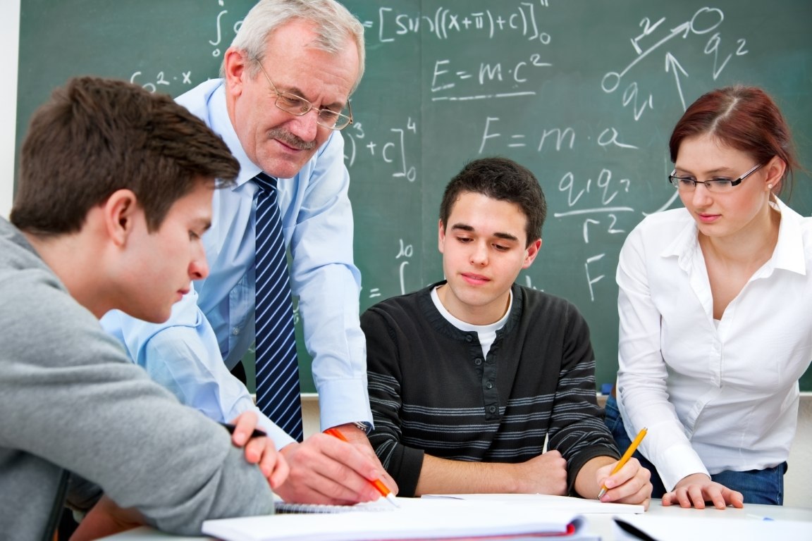 teacher with a group of high school students in classroom