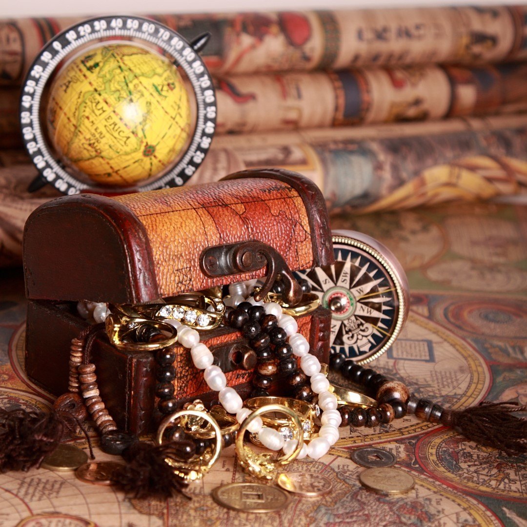 Antique chest with jewelry, compass, globe on antique map