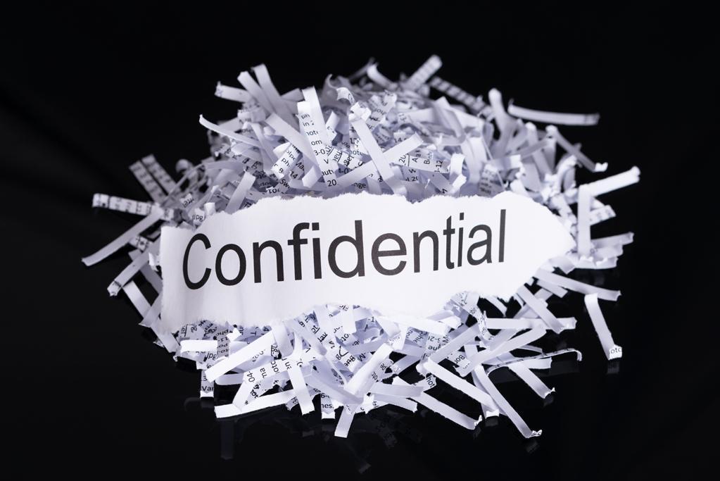 Shredded paper in data confidentiality concept over black background