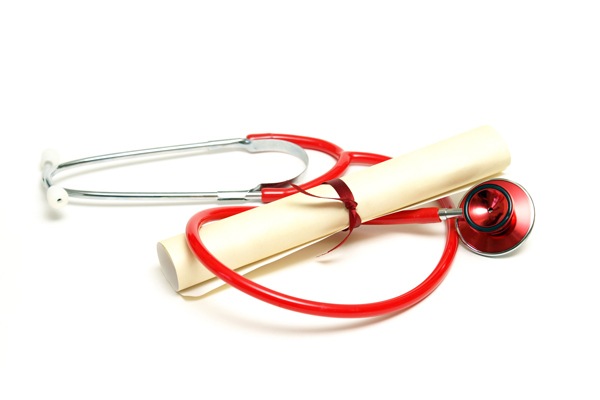 An isolated stethoscope and diploma scroll represent a graduating healthcare professional.