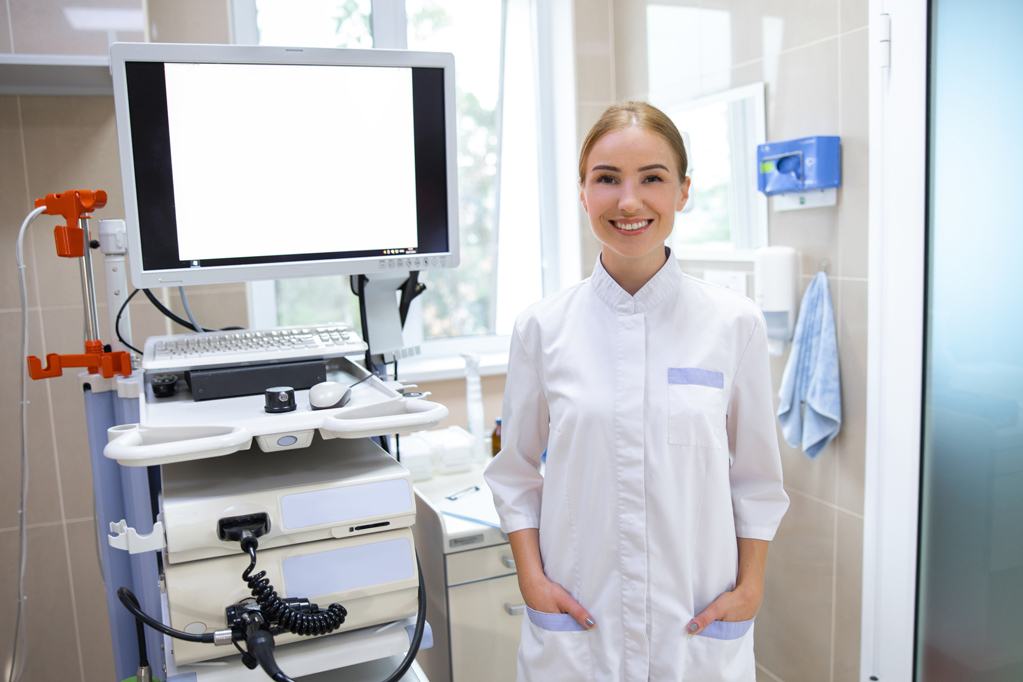 Smiling young woman is working in endoscopy office with modern machine