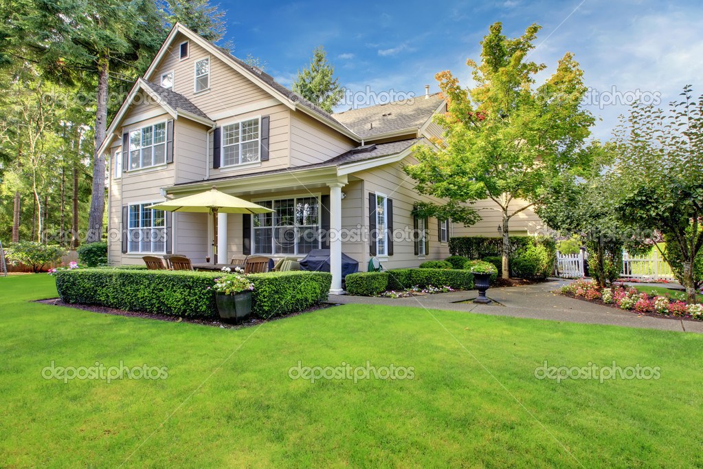 Large beige house with green grass