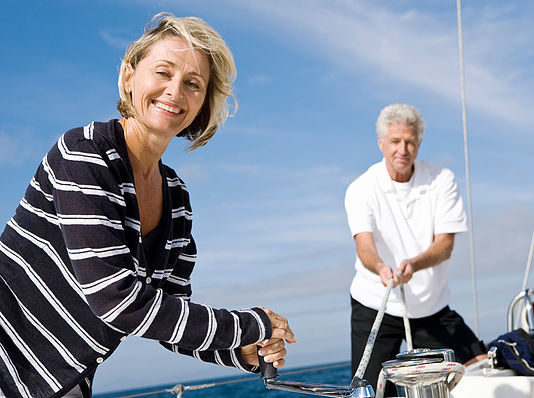 Couple pulling on rigging of sailboat